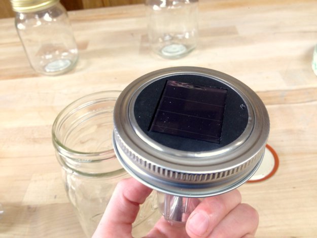 Squeeze the light into the center of the lid so it's mostly flush with the top of the jar.