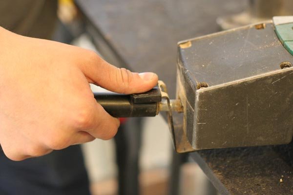 Pressing a lever with a thumb.